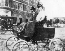 Two people pose in the first car to ever arrive in Tampa